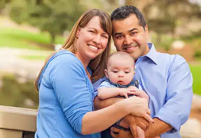 adoptive family pose together outside