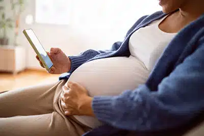pregnant woman looking at adoption profiles on her phone